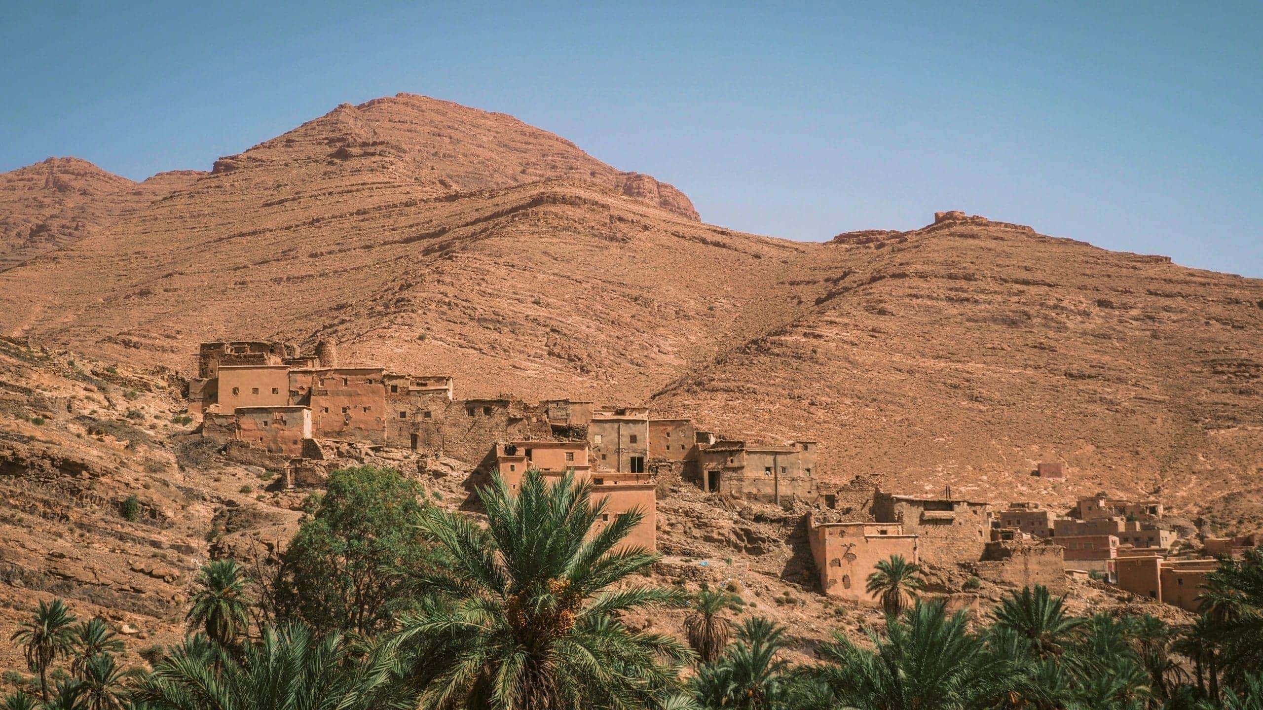Traditional Berber village surrounded by palm trees in the Atlas Mountains on Contiki's Culture & Coastlines in Morocco Tour