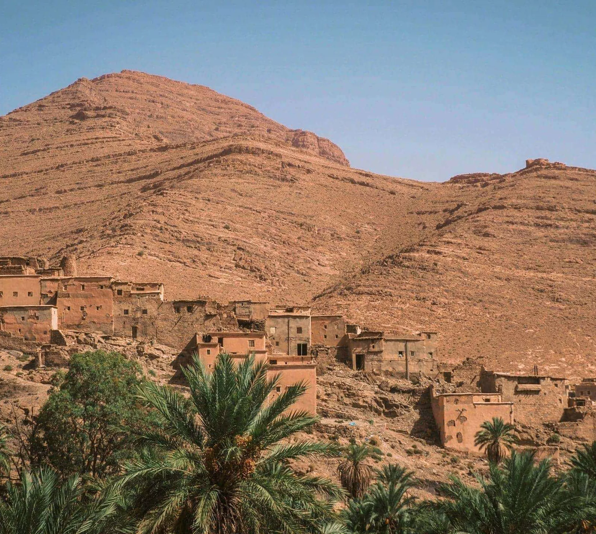 Traditional Berber village surrounded by palm trees in the Atlas Mountains on Contiki's Culture & Coastlines in Morocco Tour