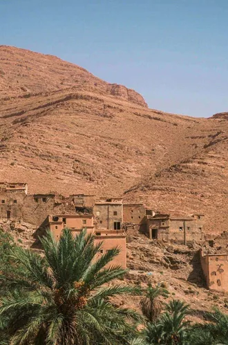 Traditional Berber village surrounded by palm trees in the Atlas Mountains on Contiki's Culture & Coastlines in Morocco Tour
