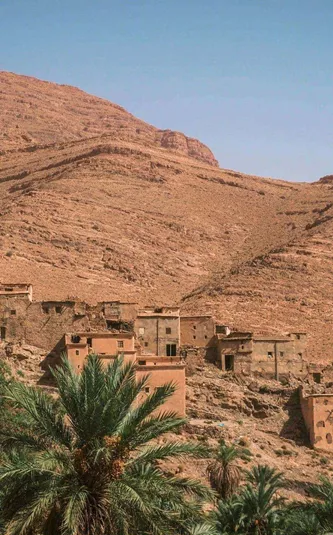 Traditional Berber village surrounded by palm trees in the Atlas Mountains on Contiki's Culture & Coastlines in Morocco Tour