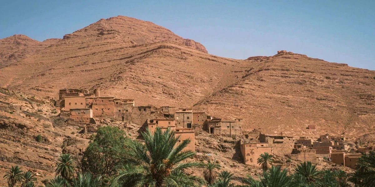 Traditional Berber village surrounded by palm trees in the Atlas Mountains on Contiki's Culture & Coastlines in Morocco Tour