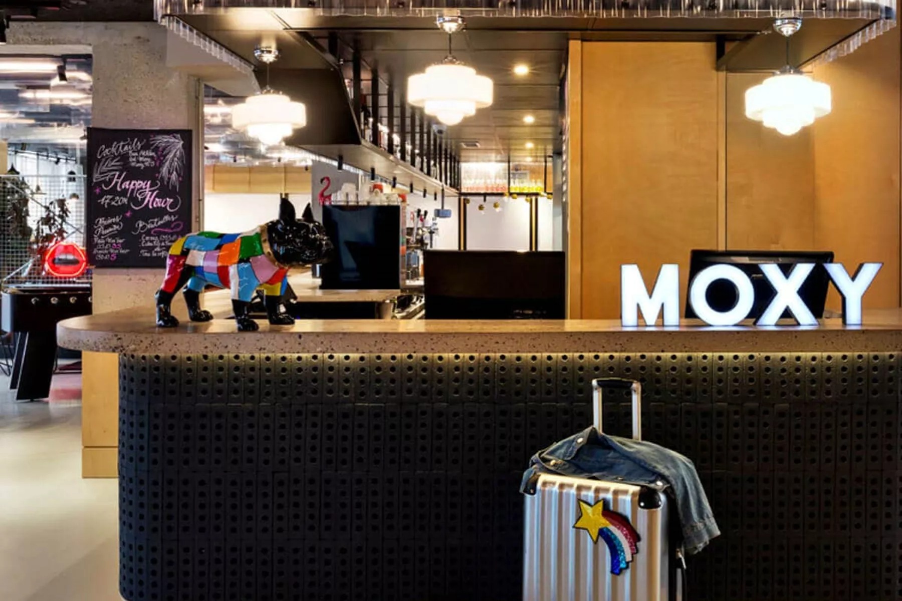 Moxy Paris Bastille check in table with bulldog statue and Moxy sign