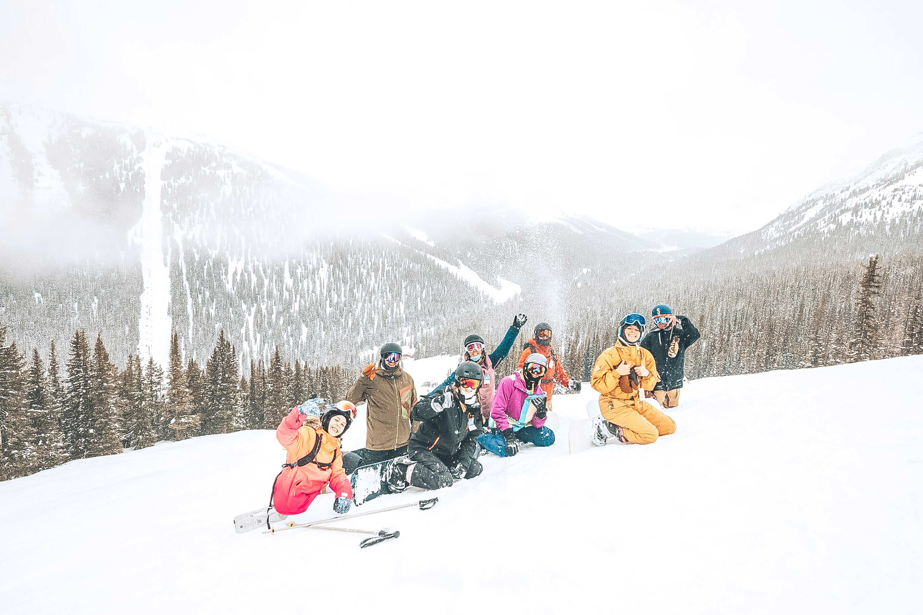 A group of skiers are posing for a photo on a snowy mountain slope