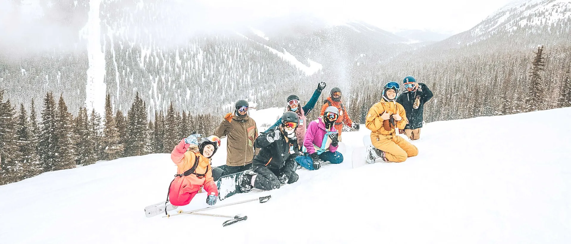 A group of skiers are posing for a photo on a snowy mountain slope