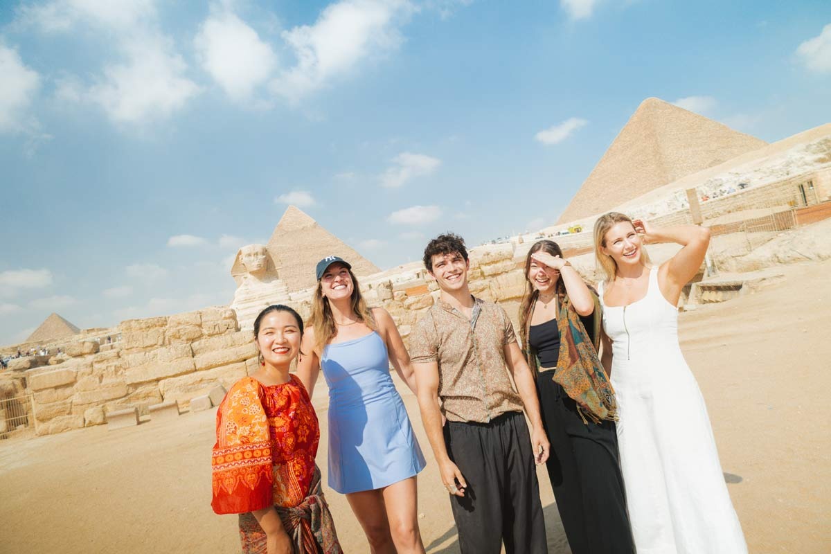 Group Of People Smiling Pyramids As Background