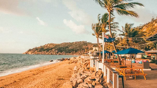 Sunny coast and a beach with umbrellas and a restaurant
