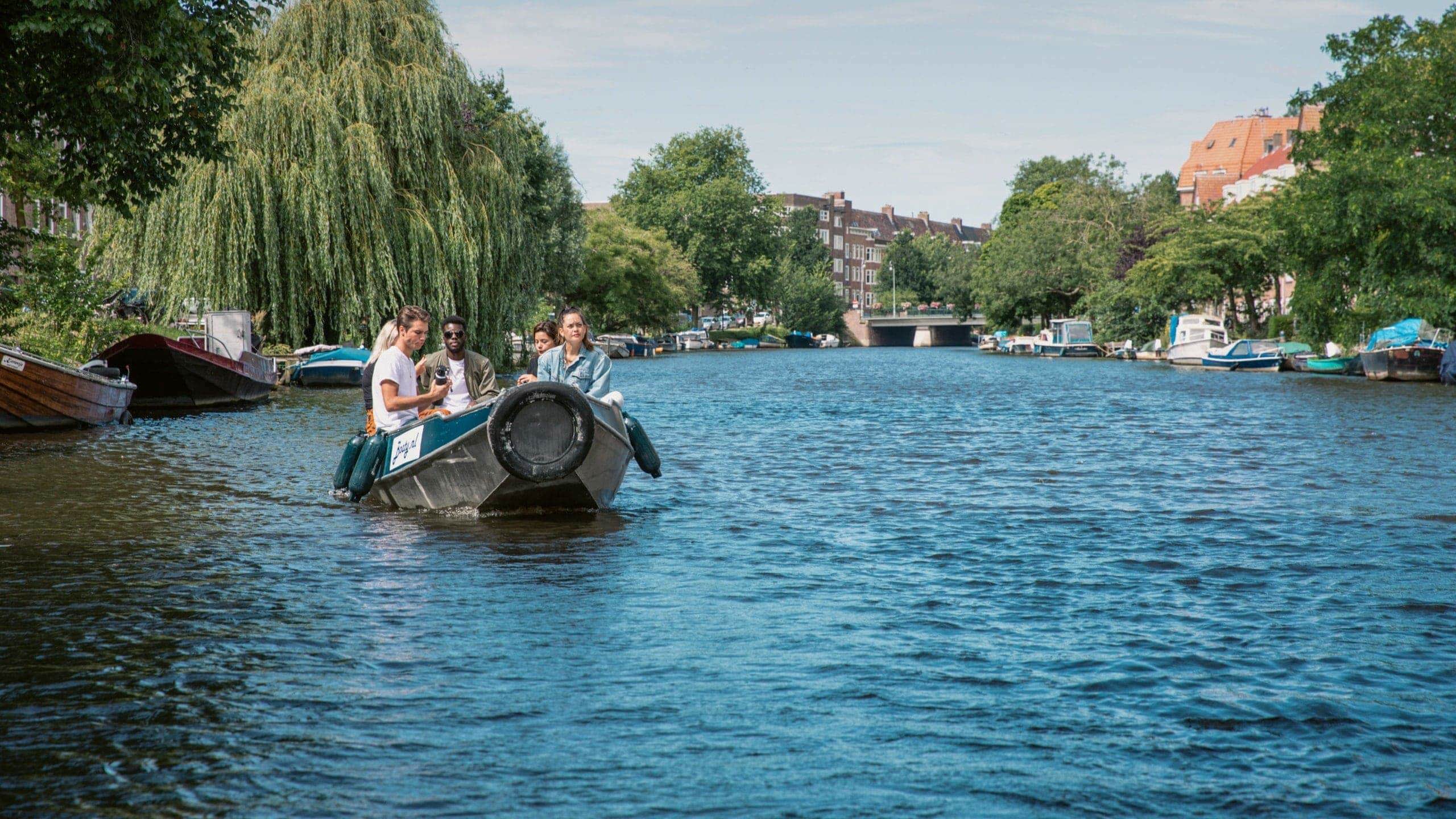 Contiki travellers cruise along Amsterdam's canals in a small boat on the European Encounter Tour