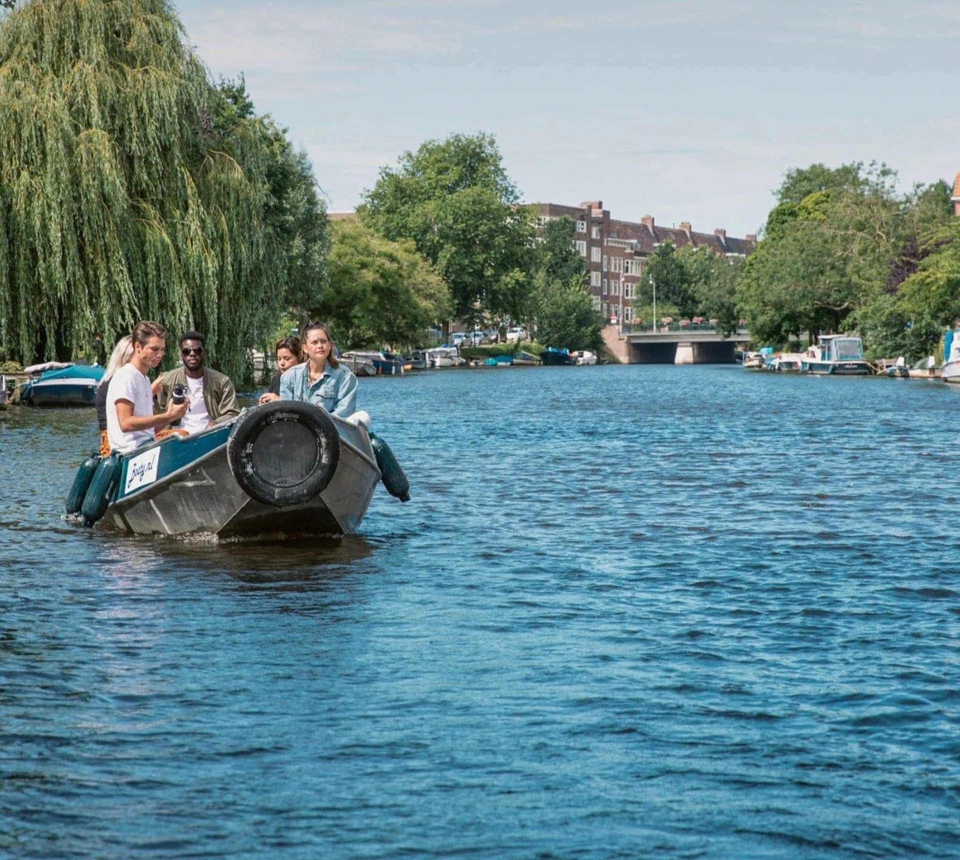 Contiki travellers cruise along Amsterdam's canals in a small boat on the European Encounter Tour