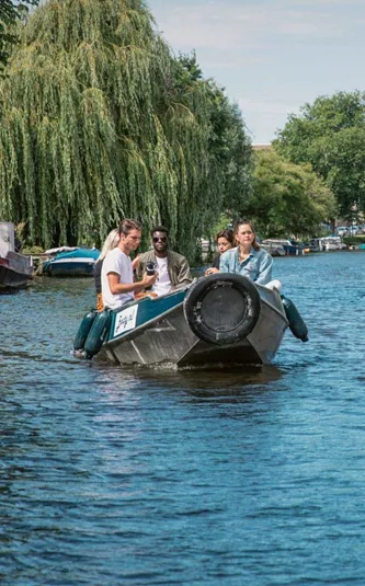 Contiki travellers cruise along Amsterdam's canals in a small boat on the European Encounter Tour