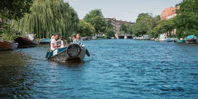 Contiki travellers cruise along Amsterdam's canals in a small boat on the European Encounter Tour