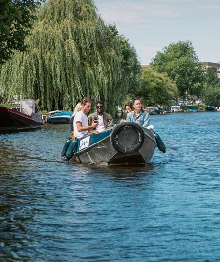 Contiki travellers cruise along Amsterdam's canals in a small boat on the European Encounter Tour