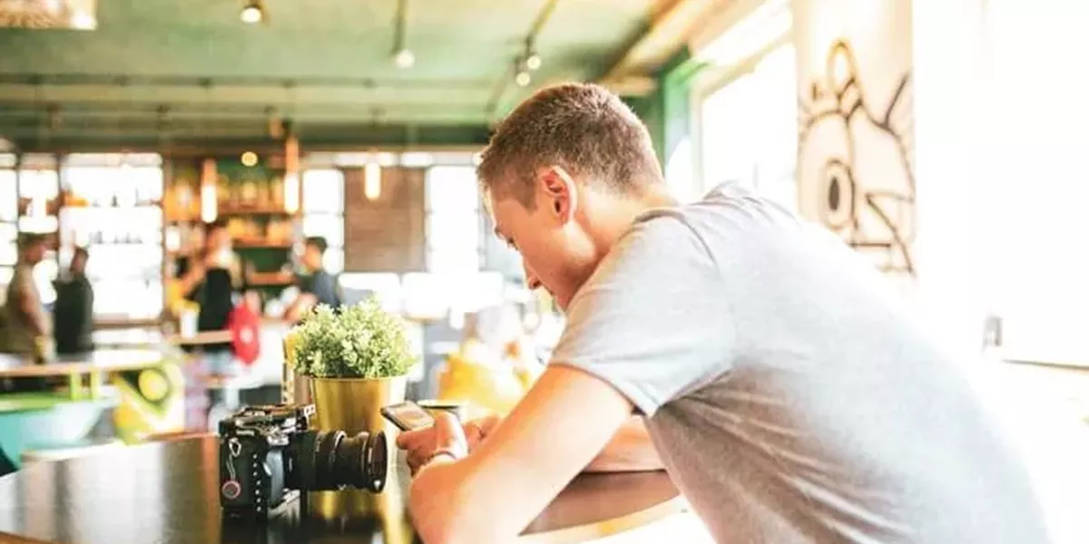 A Man Looking at His Phone in a Restaurant
