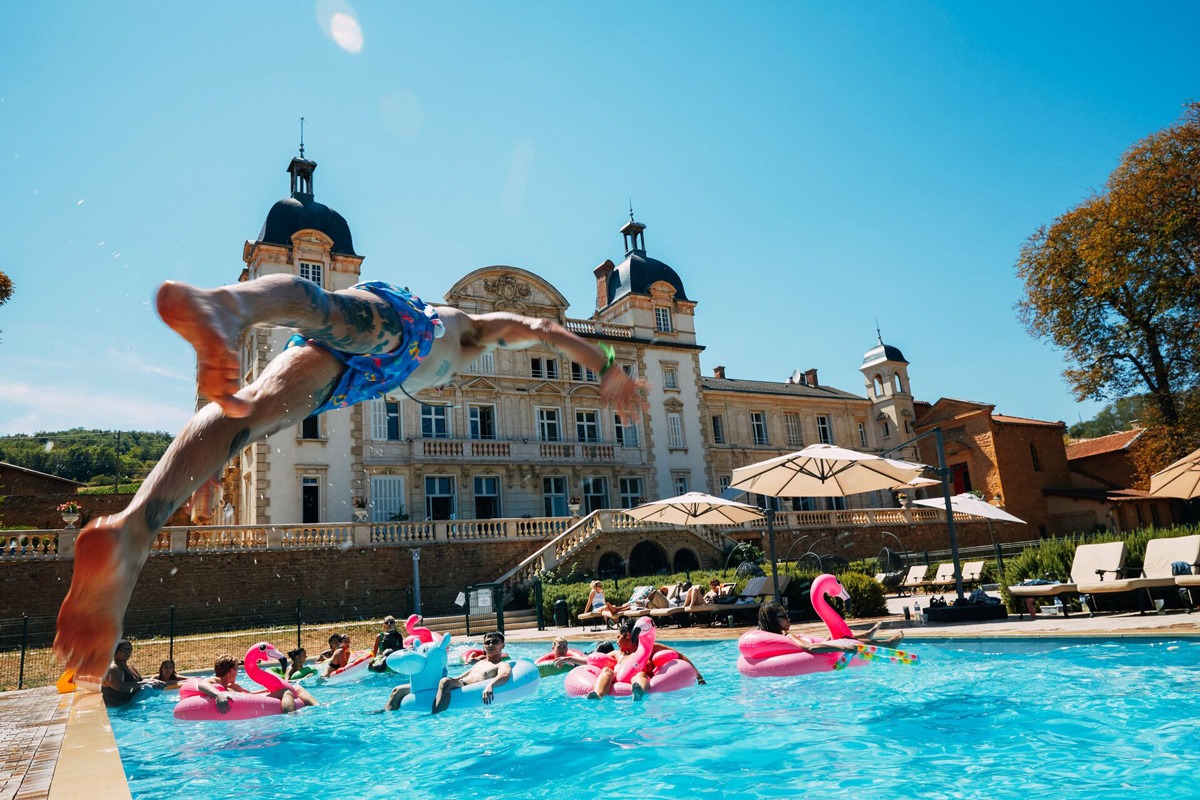 Young people having fun in a swimming pool on a sunny day in France.