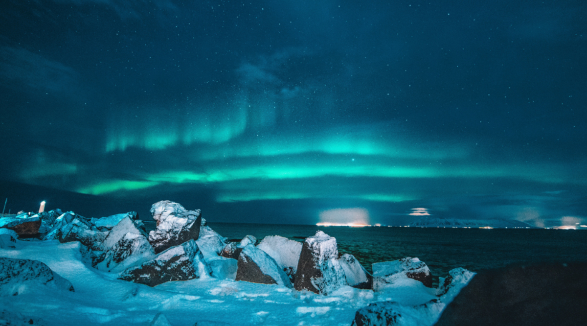 Northern Lights At Nights Rocks Covered By Snow