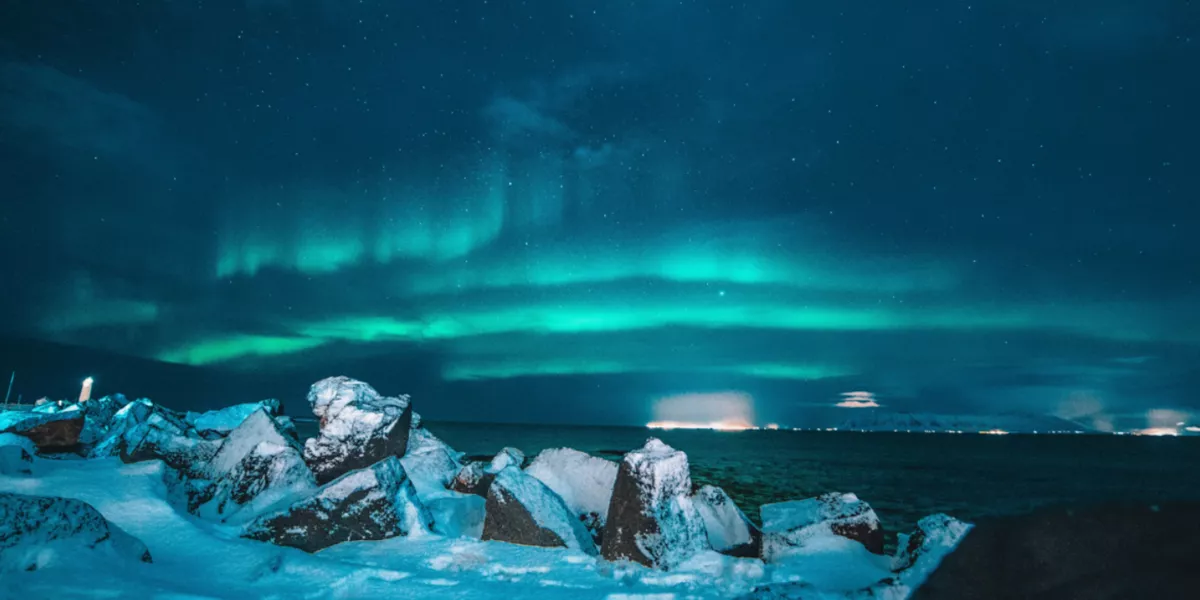 Northern Lights At Nights Rocks Covered By Snow