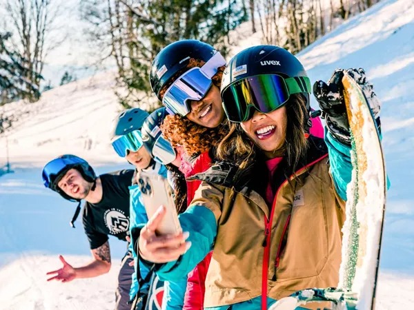 Young friends enjoying a skiing day taking a selfie in Austria.