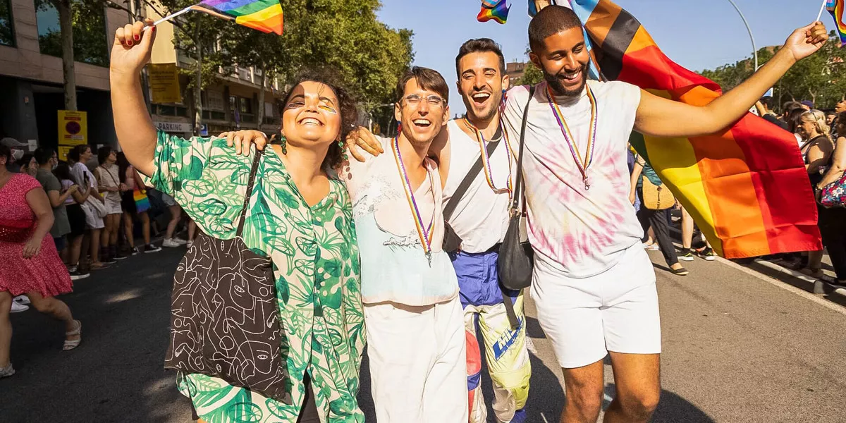 Friends Holding The Pride Flag While Smiling