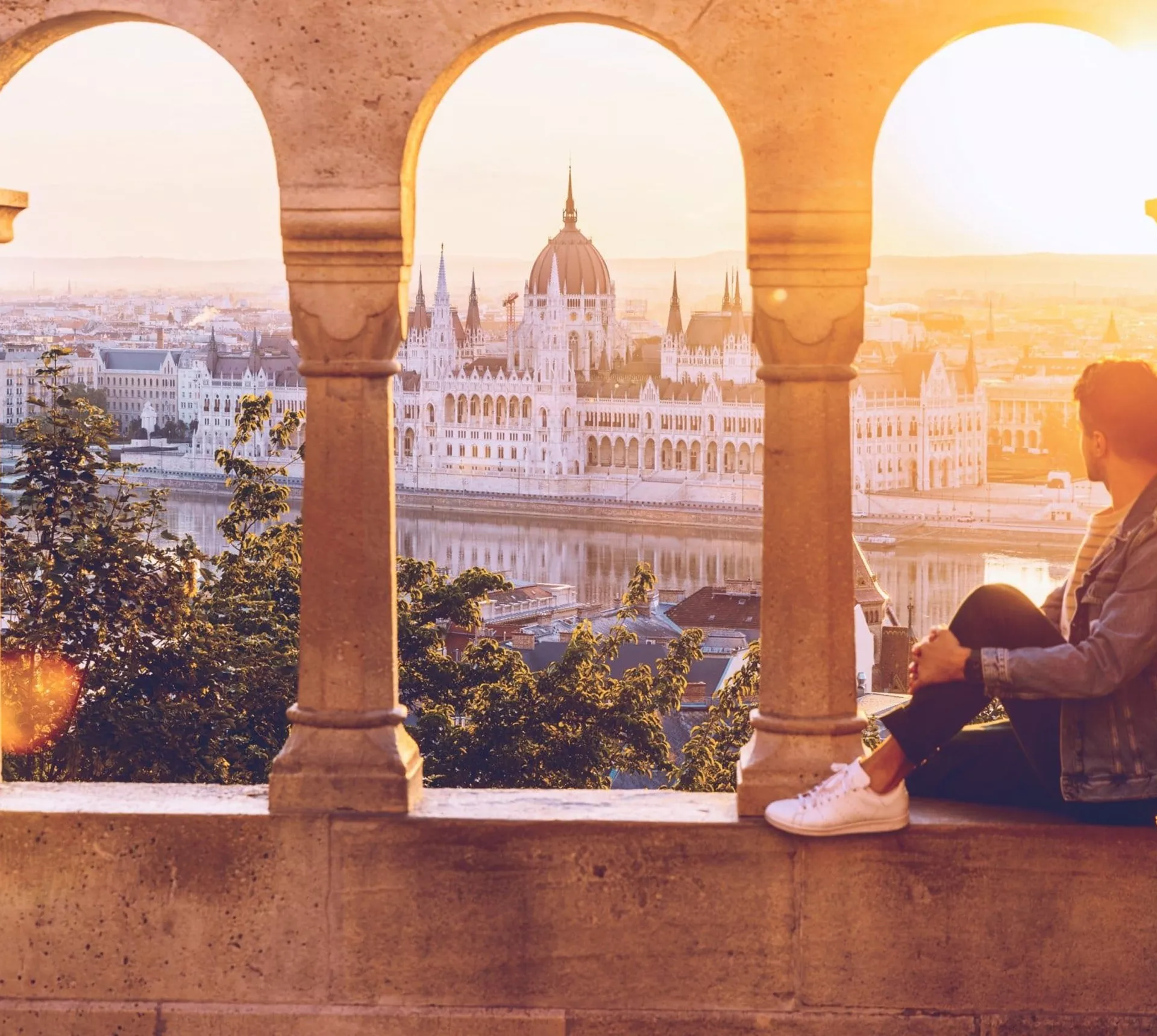 A Contiki traveller watches the sunset over the Hungarian Parliament Building from Fisherman's Bastion in Budapest on the London to Vienna Trail