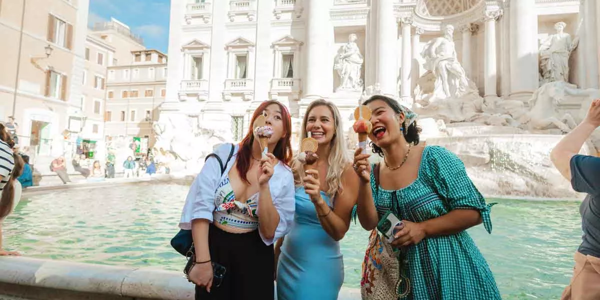 Group Of Treavellers Eating Ice Cream At Trevi Fountain Rome Italy