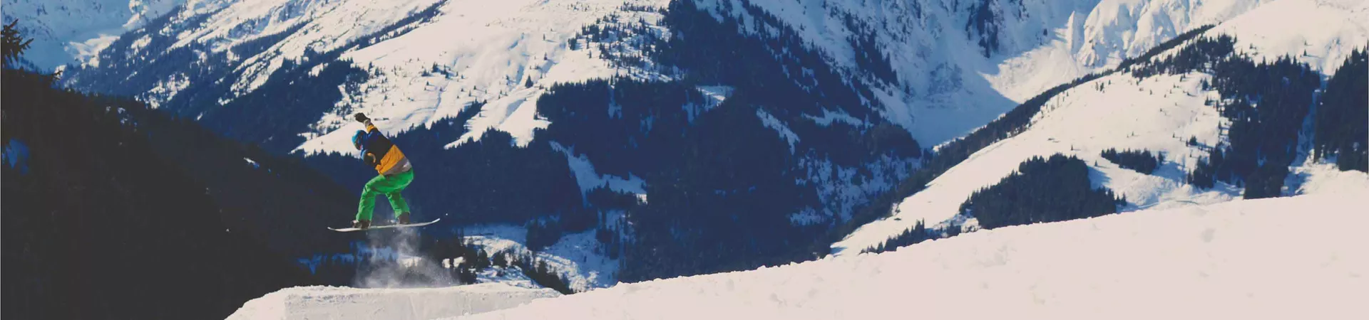 Lone Snowboarder Jumping Through Mountainscape