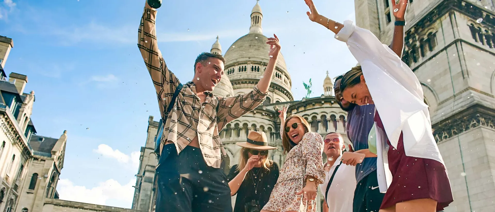 People happily jumping on a sunny-day landmark as a background in France.