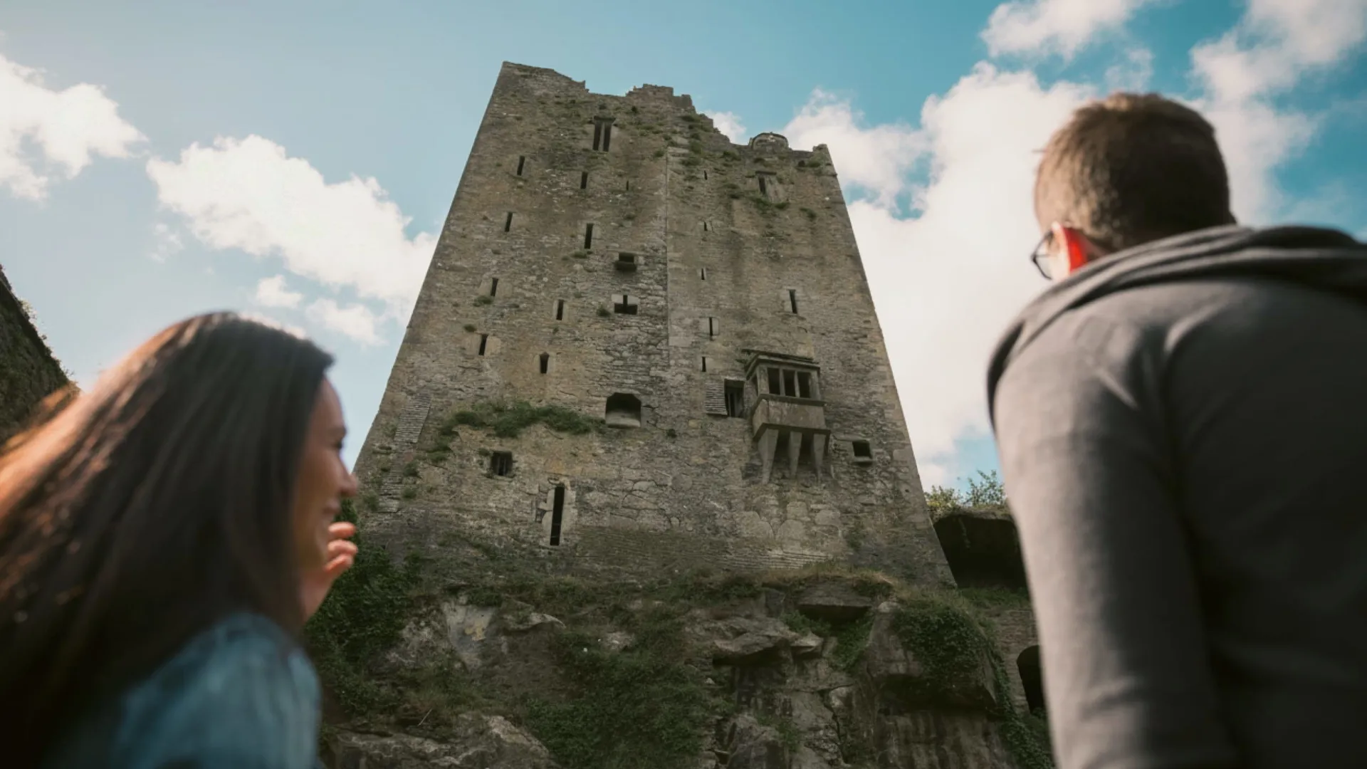 Two people look up at the historic Blarney Castle in County Cork - Contiki Ireland in a Week Tour