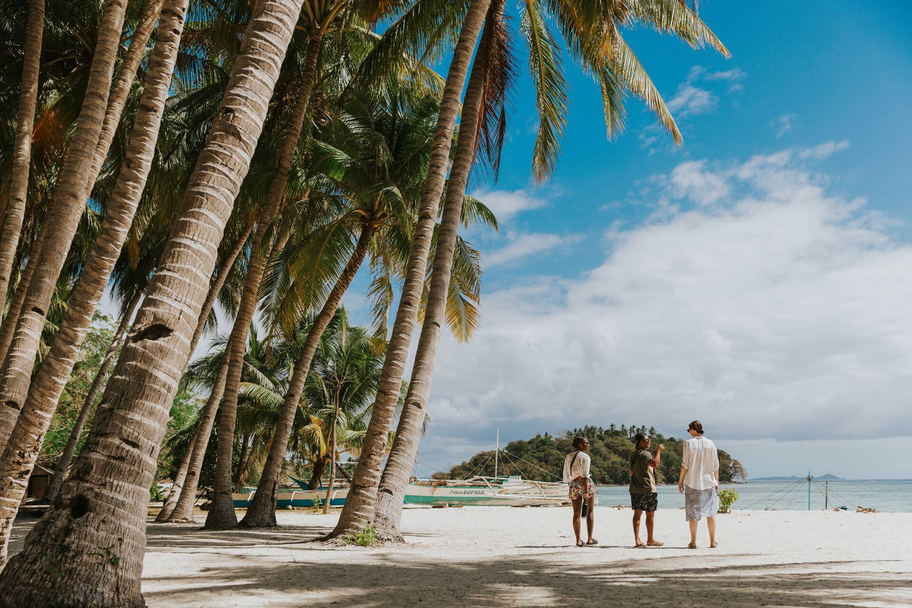 Three Friends Walking On The Beach Close To The Sea