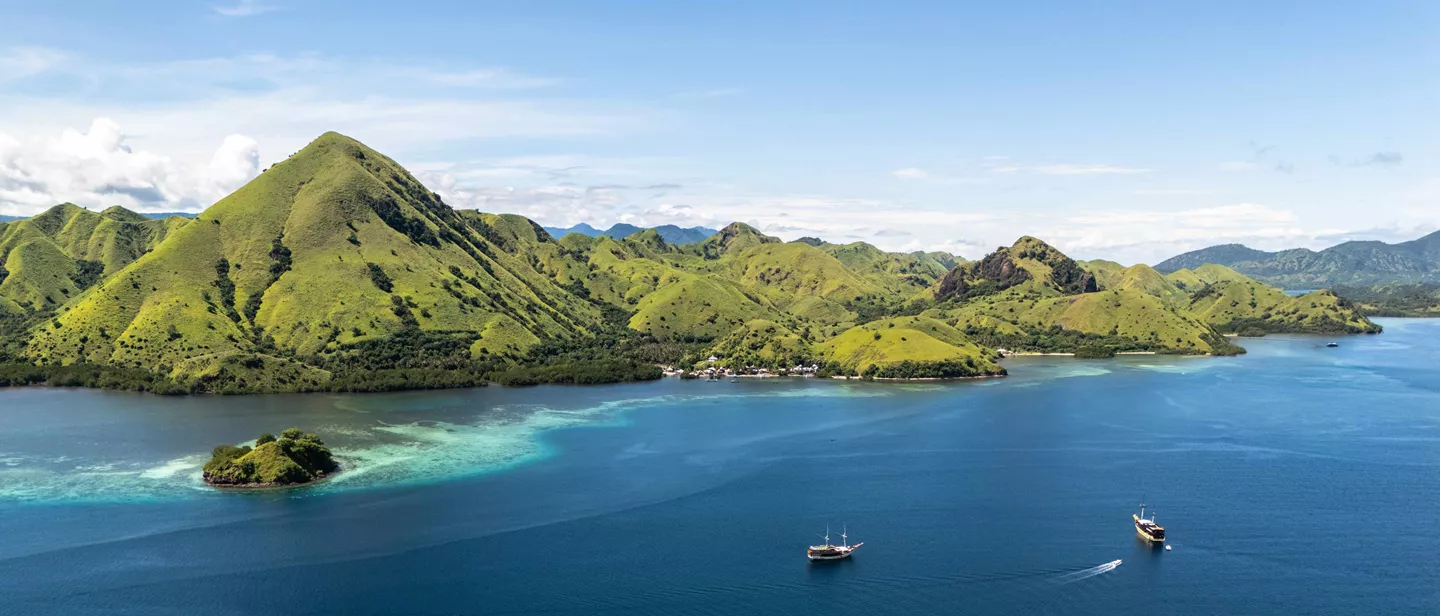 boats blue sea water green mountains