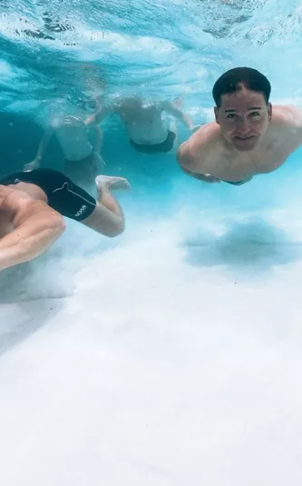 Beneath the surface of the Whitsundays, Contiki travellers swim through crystal-clear waters on the Whitsundays to Uluru Tour