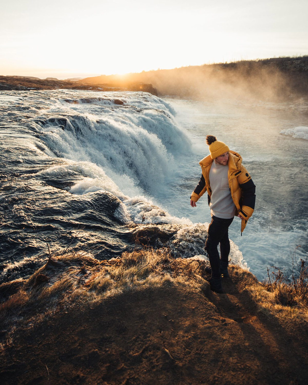 Man walking close to a waterfall in Iceland.