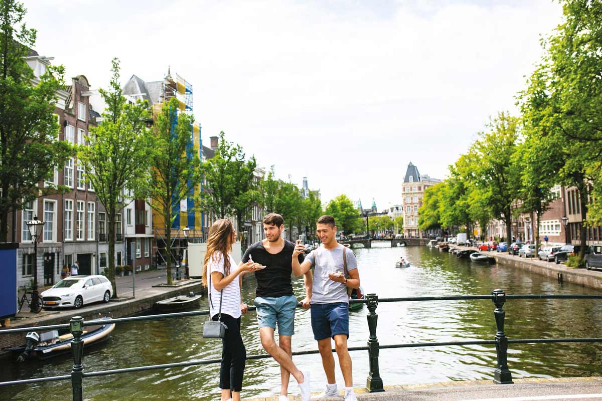 Three Friends Enjoying Food Close To Canal