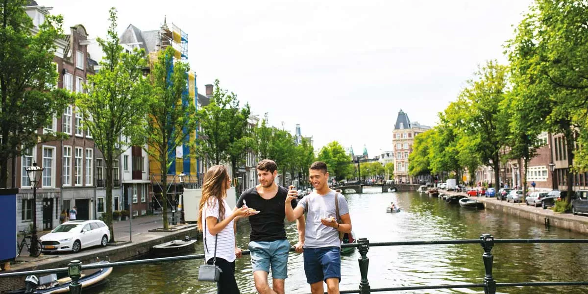 Three Friends Enjoying Food Close To Canal