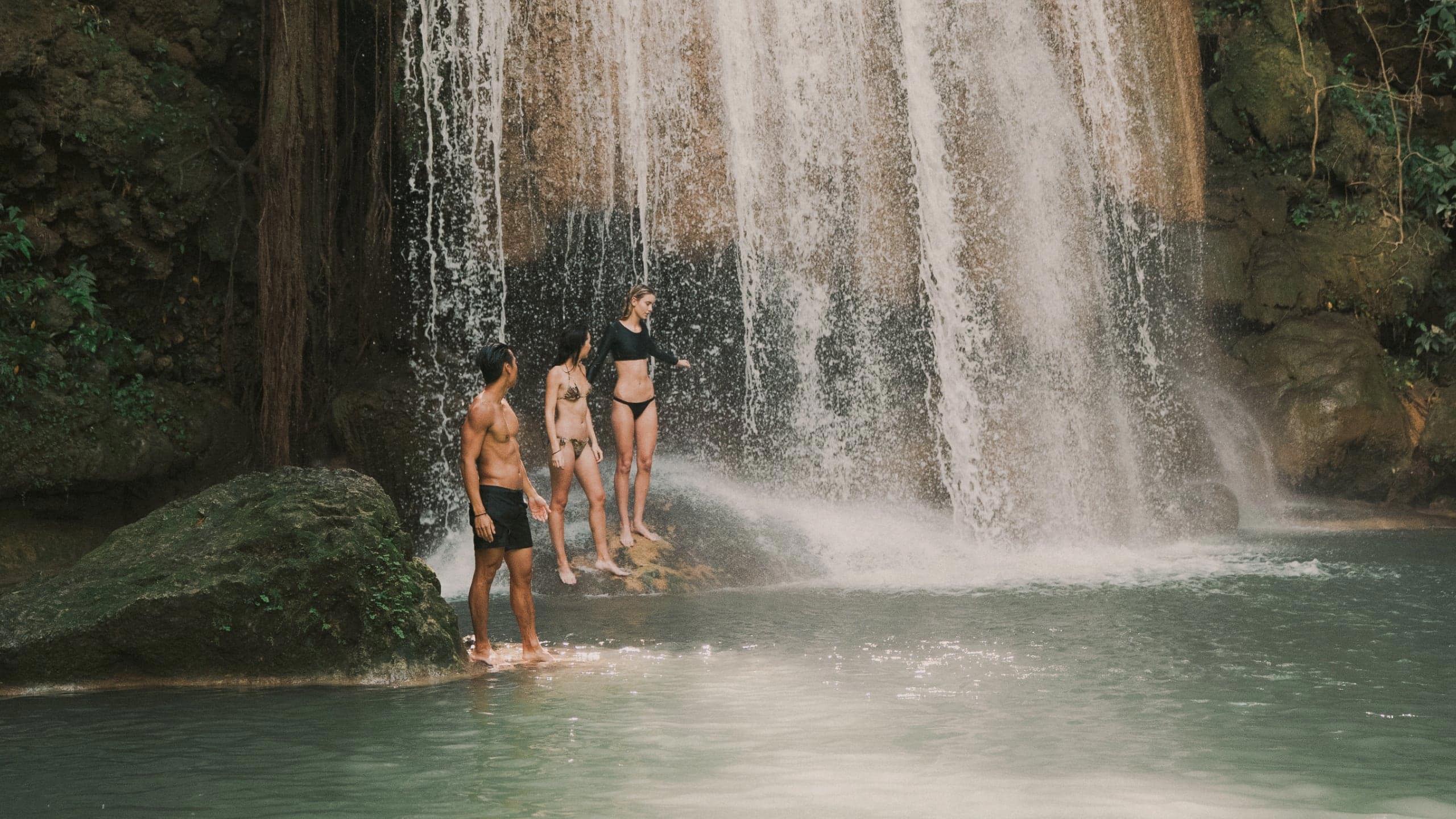 Travellers swimming beneath a tropical waterfall in Northern Thailand - Contiki Chiang Mai & Pai Tour