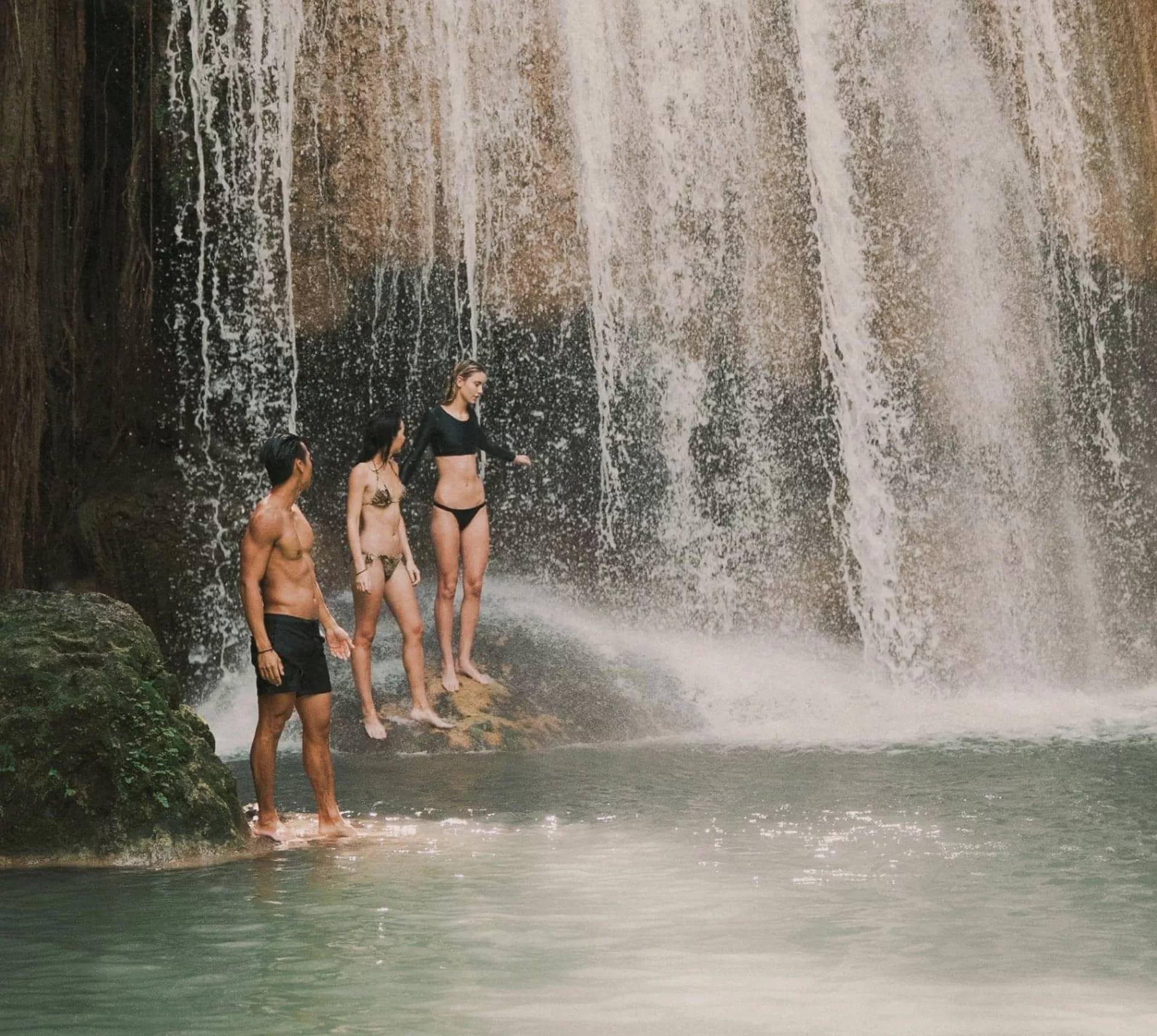 Travellers swimming beneath a tropical waterfall in Northern Thailand - Contiki Chiang Mai & Pai Tour