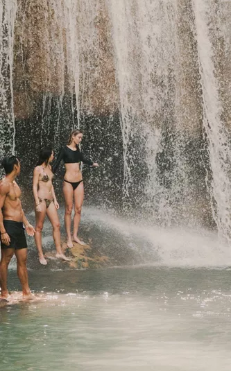 Travellers swimming beneath a tropical waterfall in Northern Thailand - Contiki Chiang Mai & Pai Tour