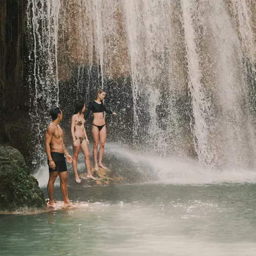 Travellers swimming beneath a tropical waterfall in Northern Thailand - Contiki Chiang Mai & Pai Tour