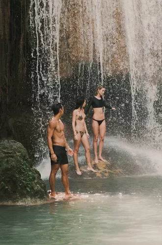 Travellers swimming beneath a tropical waterfall in Northern Thailand - Contiki Chiang Mai & Pai Tour