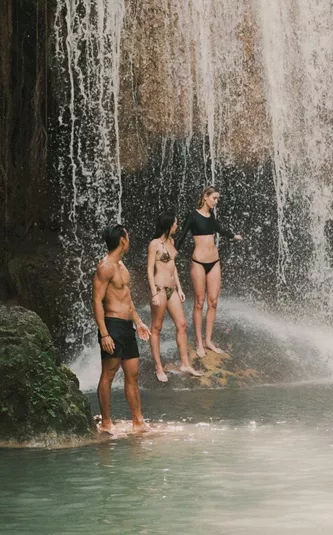 Travellers swimming beneath a tropical waterfall in Northern Thailand - Contiki Chiang Mai & Pai Tour