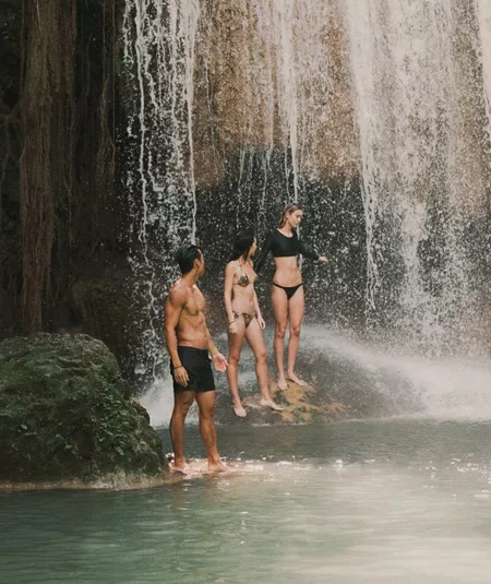 Travellers swimming beneath a tropical waterfall in Northern Thailand - Contiki Chiang Mai & Pai Tour