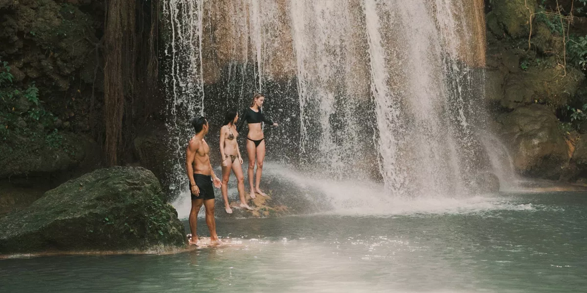 Travellers swimming beneath a tropical waterfall in Northern Thailand - Contiki Chiang Mai & Pai Tour