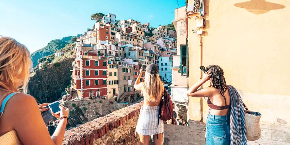 Travelers Taking Pictures Of An Italian Village On Coast
