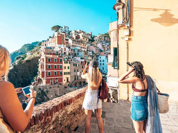 Travelers Taking Pictures Of An Italian Village On Coast