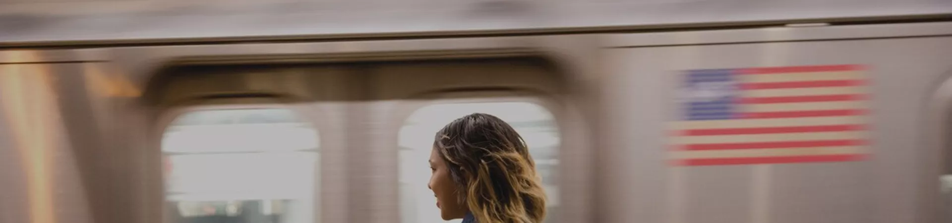 Girl with backpack and train, USA flag