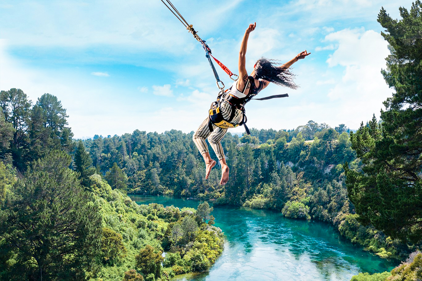 Traveller enjoying the Taupō swing above a blue river, Taupō, New Zealand