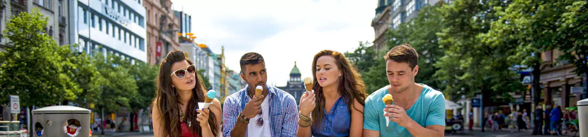 A group of young people sitting on the bench and eating ice cream