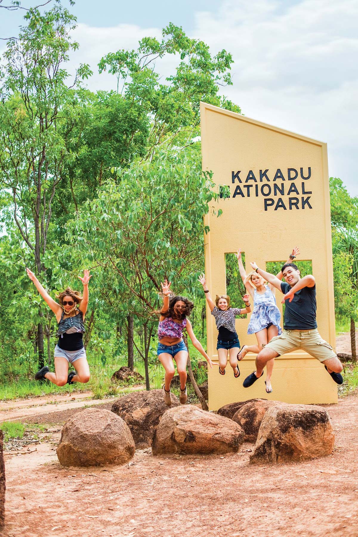 Group Of People Jumping Park Sign At The Back