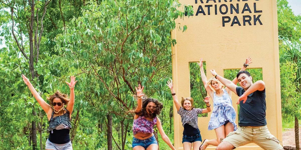 Group Of People Jumping Park Sign At The Back
