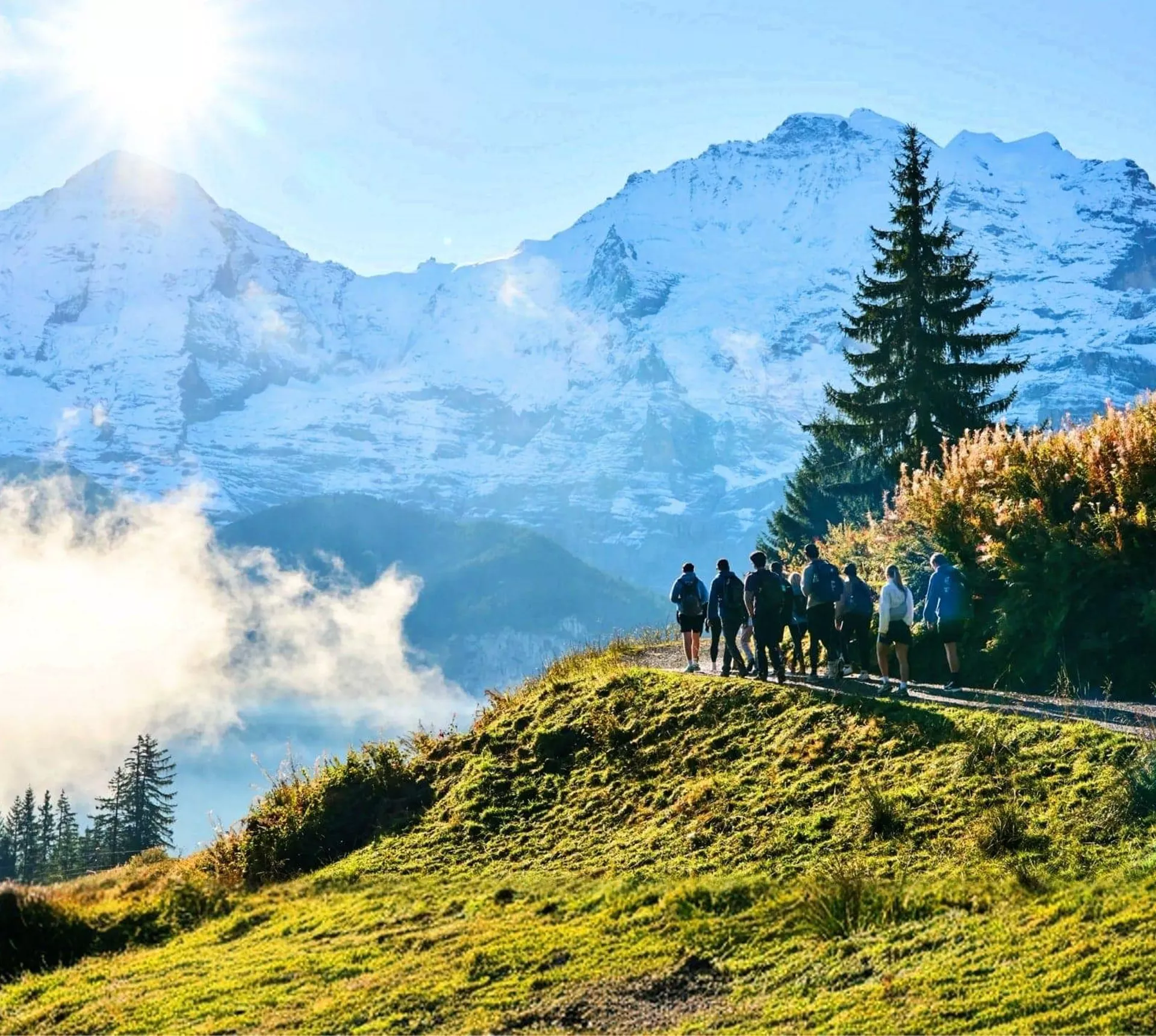 Travellers hiking through the Swiss Alps with panoramic mountain views on the Contiki Active Swiss Alps Tour
