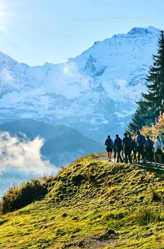 Travellers hiking through the Swiss Alps with panoramic mountain views on the Contiki Active Swiss Alps Tour