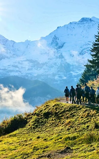 Travellers hiking through the Swiss Alps with panoramic mountain views on the Contiki Active Swiss Alps Tour